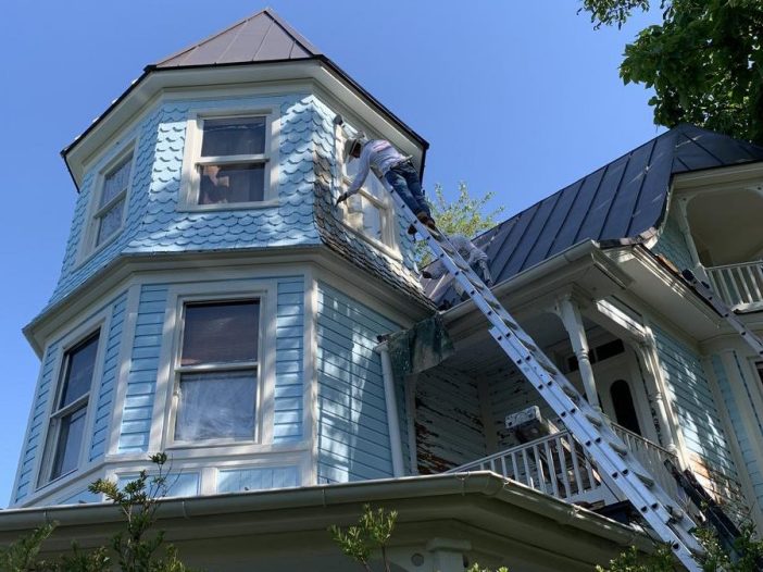 man painting house